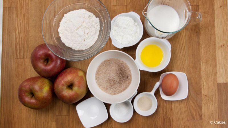 Ingredients for Dutch apple fritters on a wooden surface.