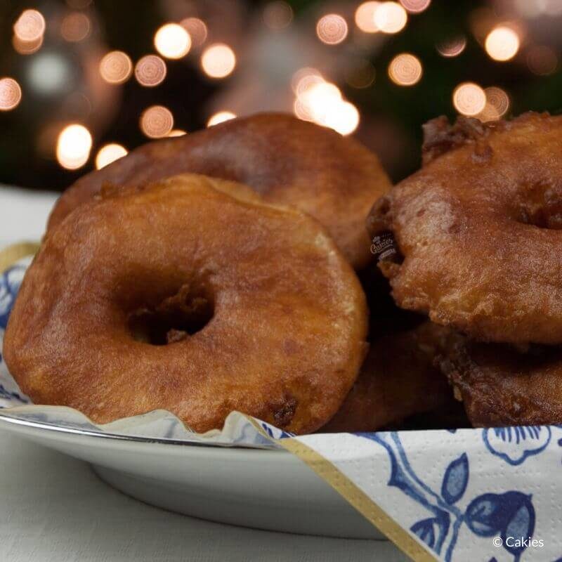 Dutch Apple Fritters on a plate with lights in the background